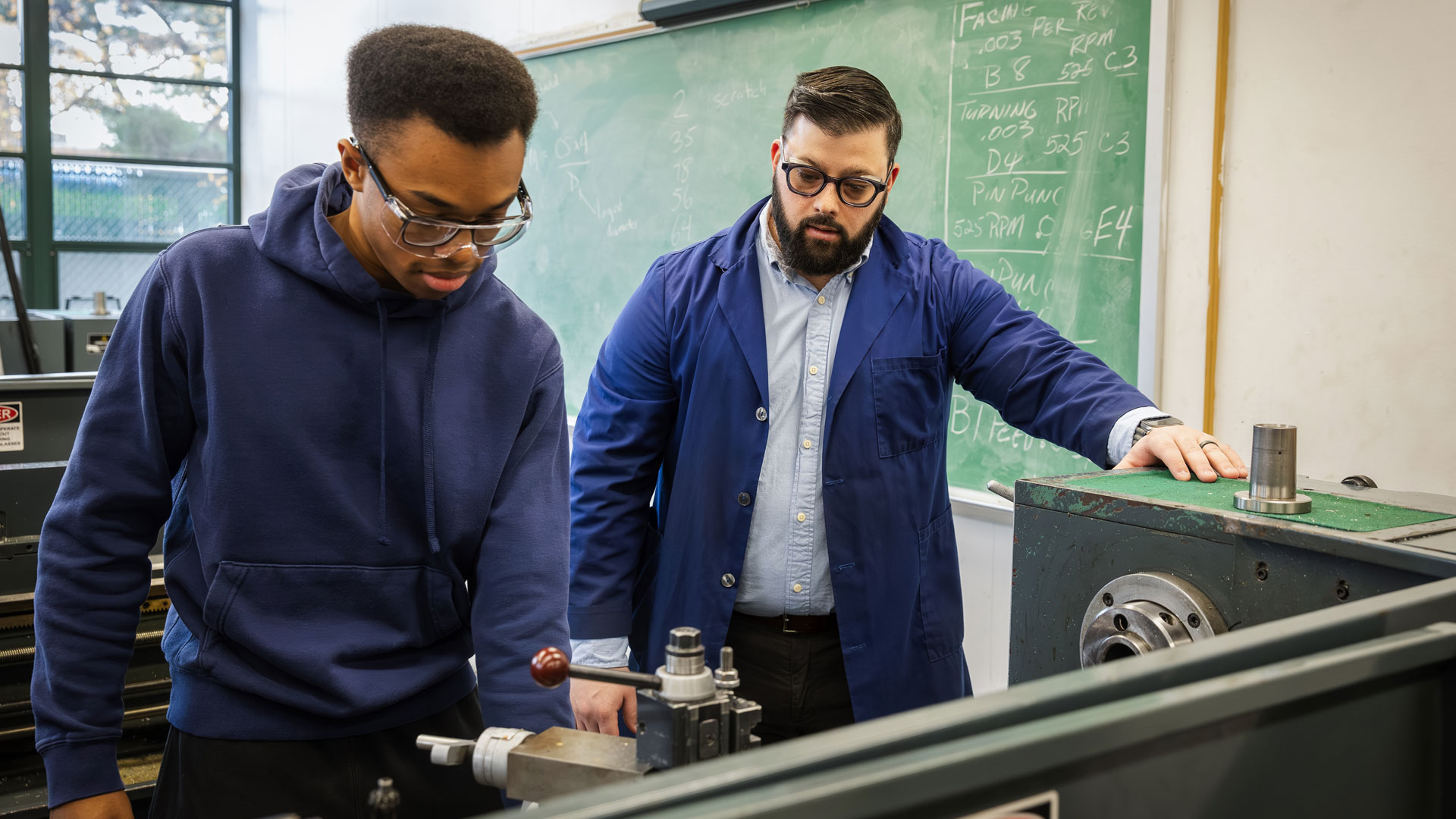 FSC Student working with professor on lathing machine